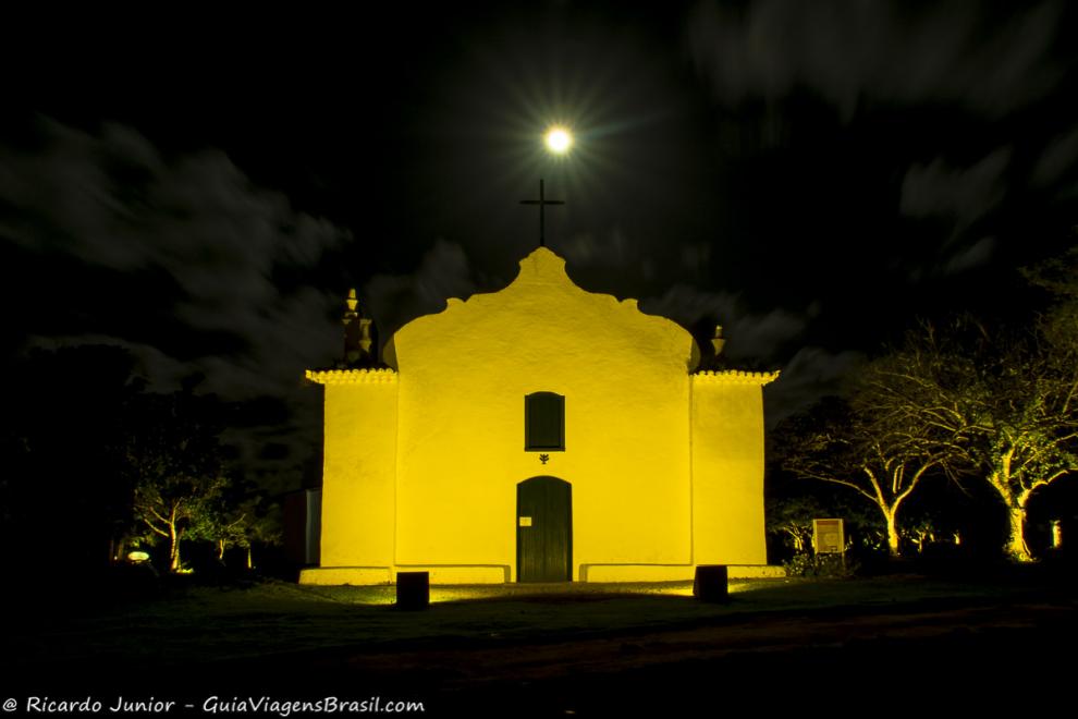 Imagem da lua maravilhosando em cima da igreja toda iluminada.